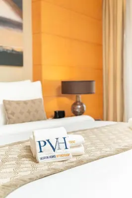 a hotel room with two beds with towels and a lamp at PVH - Emaar Fashion Avenue - 1BR Dubai Mall Access in Dubai