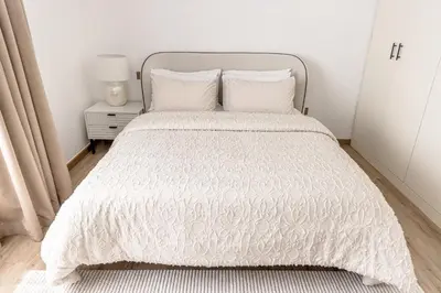 a bedroom with a bed with a white comforter at Amazing, Spacious 2-bed with fantastic sea view! in Dubai