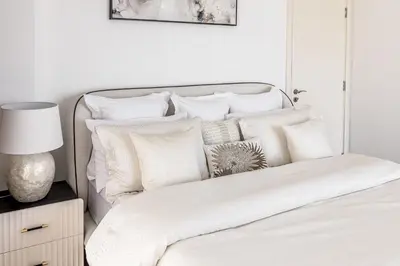 a white bedroom with a bed with white pillows at Amazing, Spacious 2-bed with fantastic sea view! in Dubai