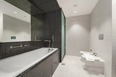 a bathroom with a tub and a toilet and a sink at FIRST CLASS 2BR Spacious DIFC Living in Dubai