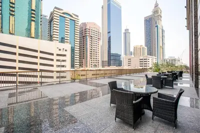 a balcony with tables and chairs and a city skyline at FIRST CLASS 2BR Spacious DIFC Living in Dubai