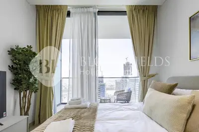 a bedroom with a bed and a large window at Bloomfields Fantastic Stu Binghatti Azure in Dubai