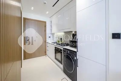a kitchen with a stove and a washer and dryer at Bloomfields Fantastic Stu Binghatti Azure in Dubai
