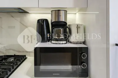a kitchen with a coffee maker on top of a microwave at Bloomfields Fantastic Stu Binghatti Azure in Dubai