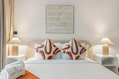a bedroom with a bed with white sheets and pillows at FIRST CLASS Studio Minimalist Chic Retreat in Dubai