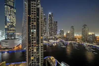 a view of a city at night with boats in the water at FIRST CLASS 1BR Majestic Marina Views in Dubai