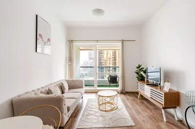 a living room with a couch and a tv at Stunning lake view 1bedroom apartment in Jlt in Dubai