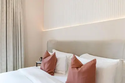 a bedroom with a bed with white sheets and pillows at Durrani Homes - Minimal Luxe 3BR with Burj Khalifa and fountain view - third room without partition in Dubai