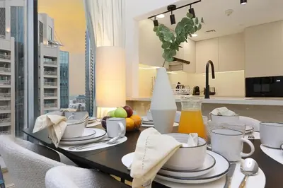 a dining room with a table with dishes on it at FIRST CLASS 2BR Burj Views & Classy Comfort in Dubai
