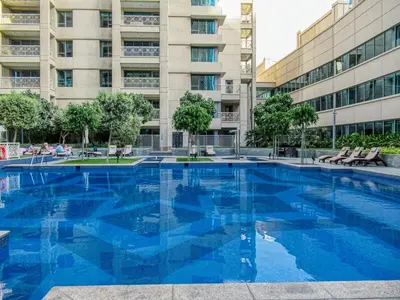 a large blue swimming pool in front of a building at FIRST CLASS 2BR Burj Views & Classy Comfort in Dubai