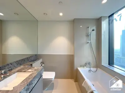 a bathroom with a tub and a toilet and a sink at Skyline Elegance, Fountain View 3BR in Downtown in Dubai