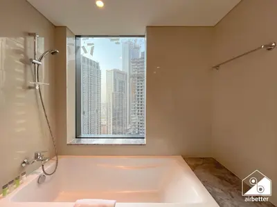 a bathroom with a large bath tub with a window at Skyline Elegance, Fountain View 3BR in Downtown in Dubai