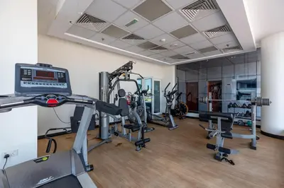 a gym with several treadmills and cardio machines at Waves - Cozy & Fully Furnished Studio in Dubai Sports City in Dubai