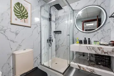 a bathroom with a shower and a toilet and a mirror at Waves - Cozy & Fully Furnished Studio in Dubai Sports City in Dubai