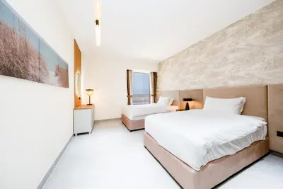 a large bedroom with two beds and a wall at Luxury 2BR - Stunning Marina View and JBR Beach in Dubai