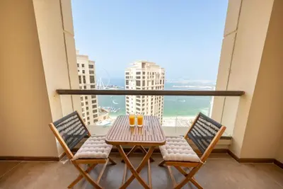 a table and chairs on a balcony with a view at Luxury 2BR - Stunning Marina View and JBR Beach in Dubai