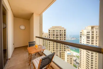 a balcony with a table and chairs and a view of the ocean at Luxury 2BR - Stunning Marina View and JBR Beach in Dubai