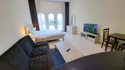 a living room with a couch and a tv at DRUVYA HOLIDAY HOMES, Building No 194, Street No,10 Discovery Gardens, Close to Al Furjan Metro 3 minutes walkable in Dubai