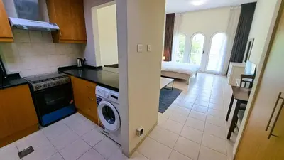 a kitchen with a washing machine in the middle of a room at DRUVYA HOLIDAY HOMES, Building No 194, Street No,10 Discovery Gardens, Close to Al Furjan Metro 3 minutes walkable in Dubai