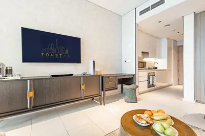 a kitchen with a table with a bowl of fruit on it at Deluxe Studio Business Bay - Balcony City Skyline Views in Dubai