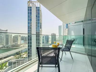 a table and chairs on a balcony with a view of a city at Deluxe Studio Business Bay - Balcony City Skyline Views in Dubai