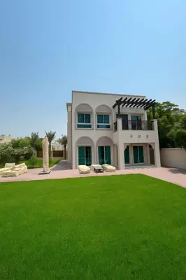 a large house with a green lawn in front of it at Family Villa, Sleeps up to 9 in JVT and Large garden in Dubai