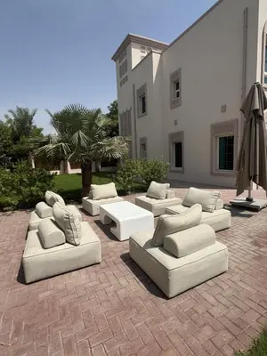 a group of white couches sitting on a brick patio at Family Villa, Sleeps up to 9 in JVT and Large garden in Dubai