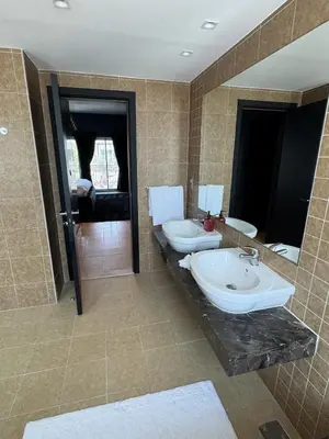 a bathroom with two sinks and a large mirror at Family Villa, Sleeps up to 9 in JVT and Large garden in Dubai