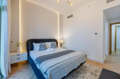 a bedroom with a bed with a blue and white blanket at Exceptional 2BR with Marina Waterfront View in Dubai