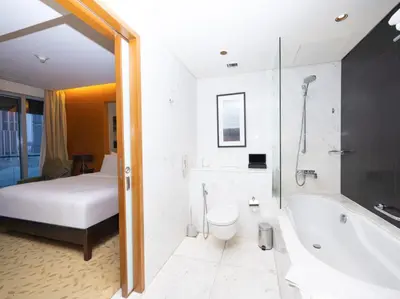 a bathroom with a tub and a bed and a bath tub at Emaar Residenc Fashion Avenue - Sokoon in Dubai