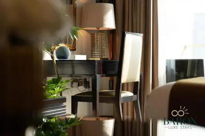 a desk with a lamp and a chair in a room at The Majestic in Dubai