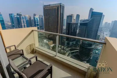 a balcony with two chairs and a view of a city at The Majestic in Dubai
