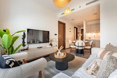 a living room with a couch and a table at 1BR with Maid's Room, Few Minutes Drive to Downtown Dubai, Burj Khalifa, Dubai Mall, Close to Parks and Crystal Lagoons - The Crest Tower C, Sobha Hartland by Deluxe Holiday Homes in Dubai
