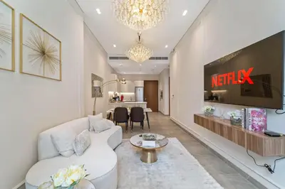 a living room with a white couch and a tv at Brand New Stylish Unit near Circle Mall in Dubai