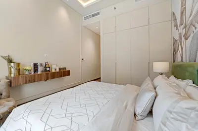 a white bedroom with a bed and a couch at Brand New Stylish Unit near Circle Mall in Dubai