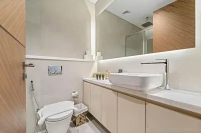 a bathroom with a sink and a toilet and a mirror at Brand New Stylish Unit near Circle Mall in Dubai