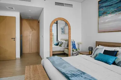 a bedroom with a large bed and a mirror at Palace Residence Chic 2BR Creek Beach View in Dubai