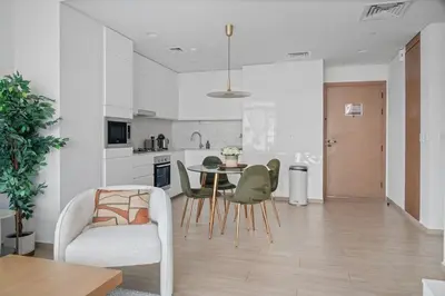 a kitchen and living room with a table and chairs at Palace Residence Chic 2BR Creek Beach View in Dubai