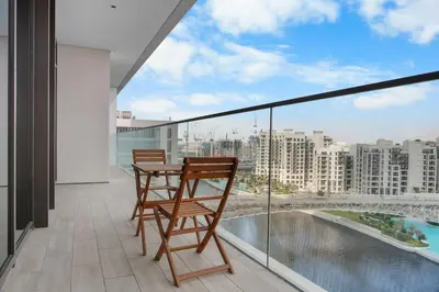 a balcony with two chairs and a table with a view at Palace Residence Chic 2BR Creek Beach View in Dubai