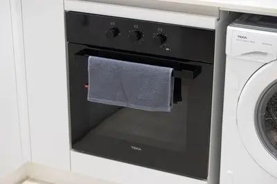 a black oven with a towel hanging from it at Luxury Top Floor Apartment in JVC in Dubai