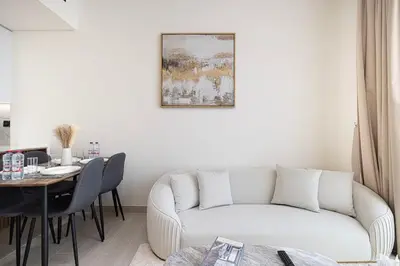 a living room with a white couch and a table at Luxury Top Floor Apartment in JVC in Dubai