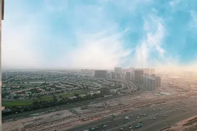 an aerial view of a city with cars on a highway at Luxury Top Floor Apartment in JVC in Dubai