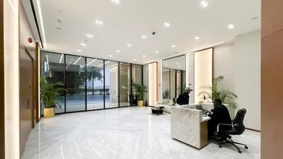 a man sitting at a desk in a lobby at Luxury Top Floor Apartment in JVC in Dubai