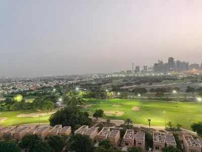 a golf course with the city in the background at Newly Furnished Luxury 2BR - Perfect for a Family Getaway in Dubai