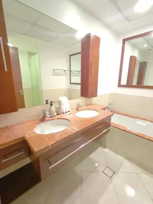 a bathroom with two sinks and a large mirror at Newly Furnished Luxury 2BR - Perfect for a Family Getaway in Dubai