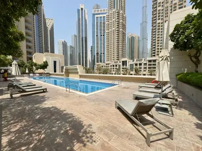 a pool with chaise lounges and chairs in a city at Lux Upscale Living Walk to Dubai Mall in Dubai