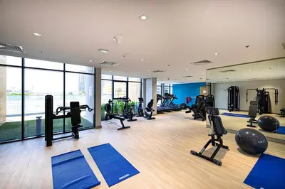 a gym with lots of treadmills and exercise equipment at Studio in Azizi Riviera in Dubai