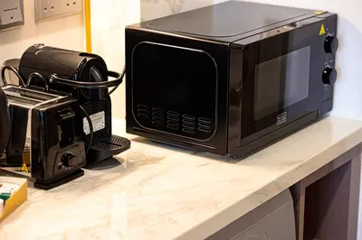 a microwave sitting on a counter next to a camera at Studio in Azizi Riviera in Dubai