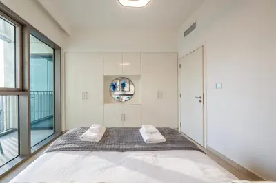 a bedroom with a large bed and a large window at Upscale 2BR with Burj Khalifa Views in Dubai