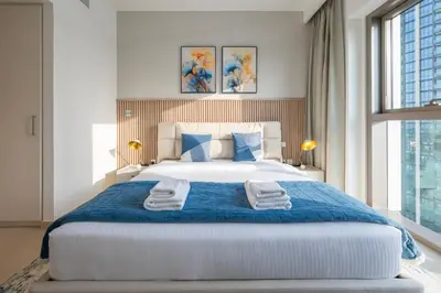 a bedroom with a large bed with towels on it at Upscale 2BR with Burj Khalifa Views in Dubai